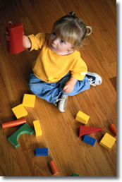 infant girl playing with blocks